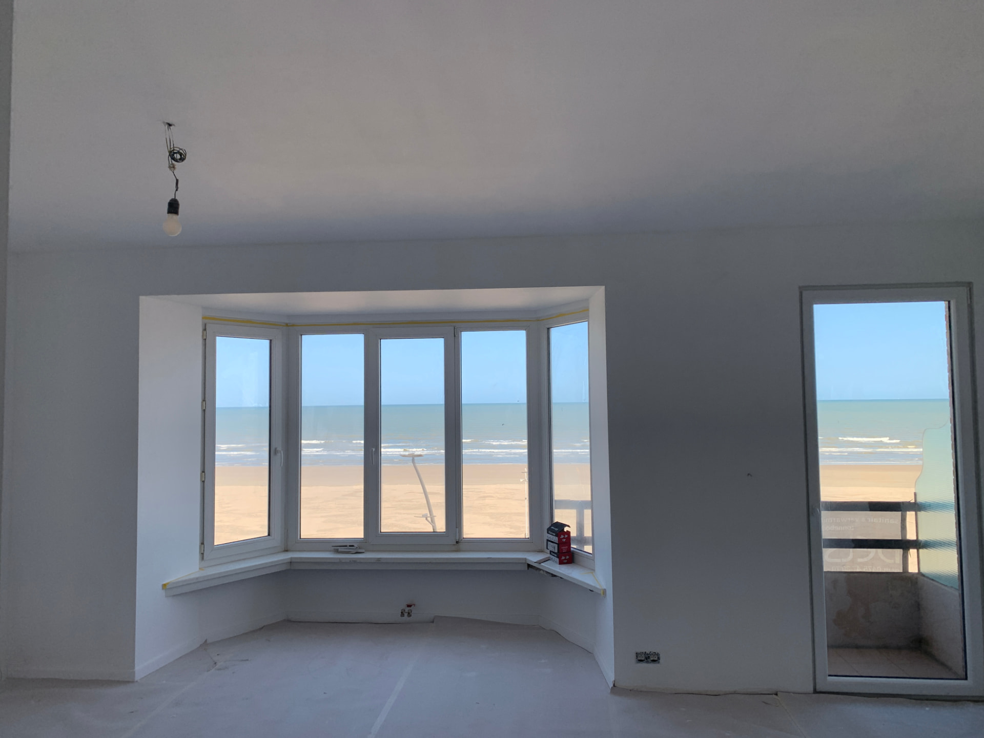 Dezelfde leefruimte met zeezicht na de renovatie