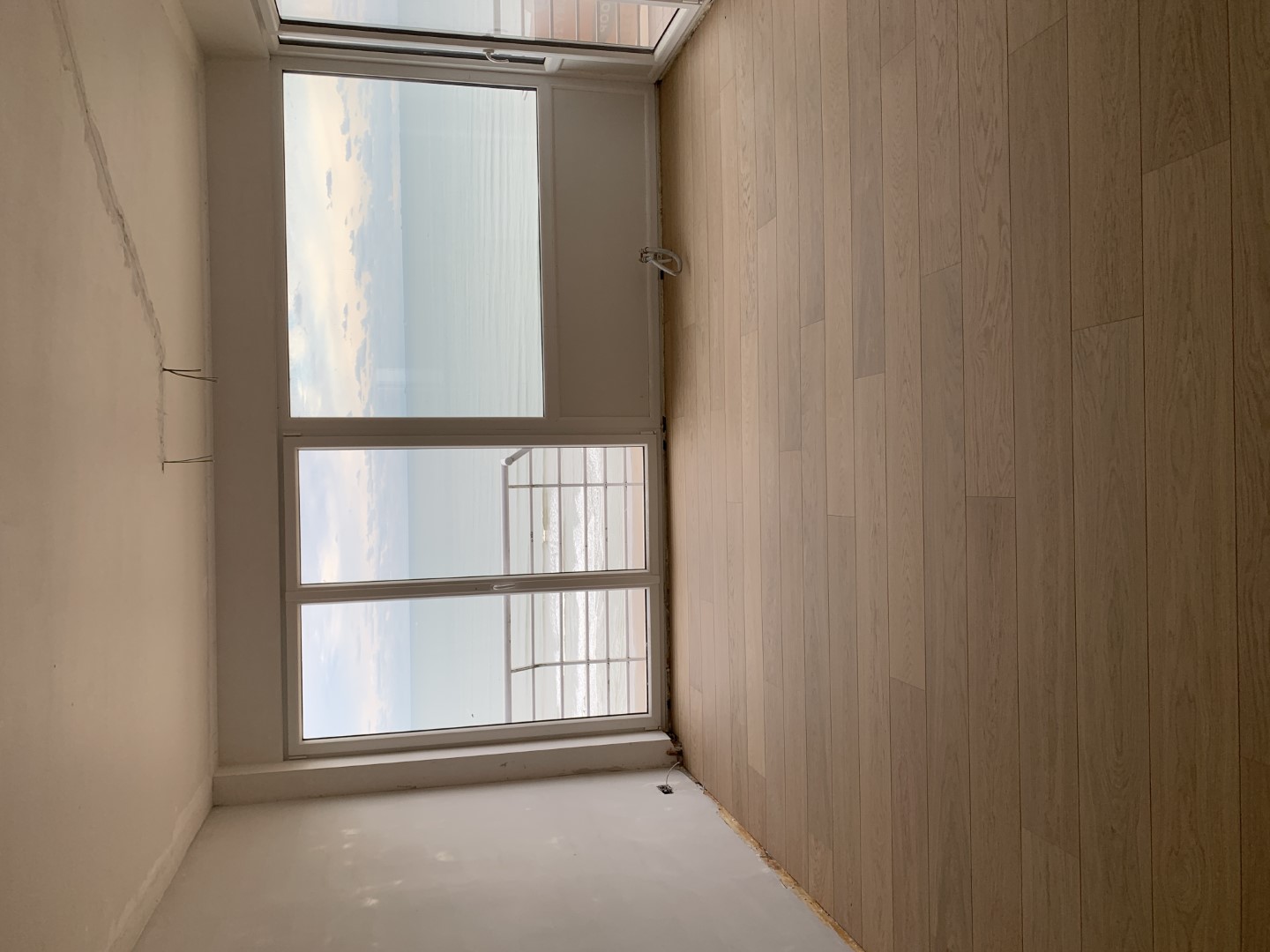Dezelfde leefruimte met nieuwe parketvloer na de renovatie