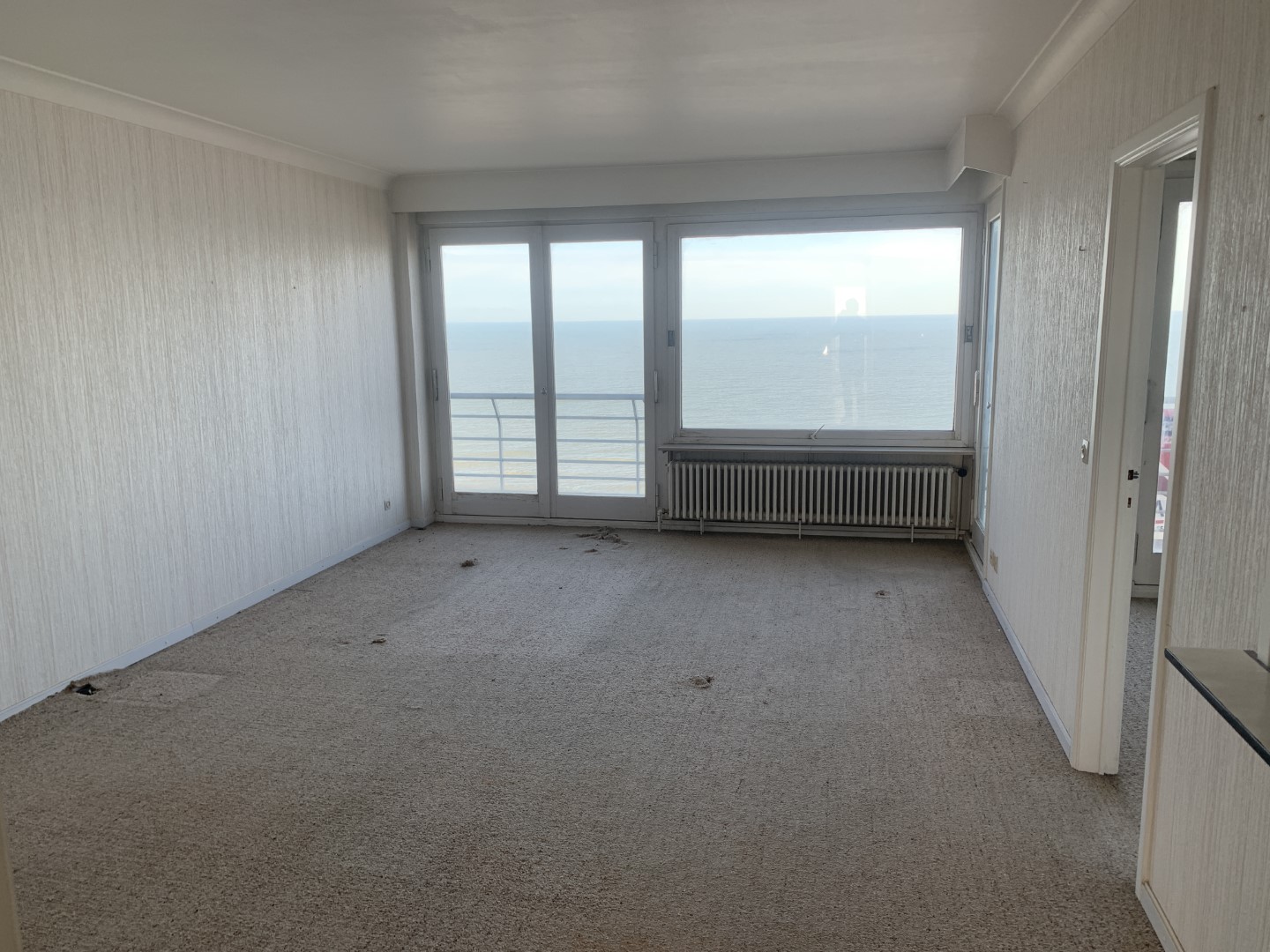 Leefruimte met oude vloerbekleding voor de renovatie