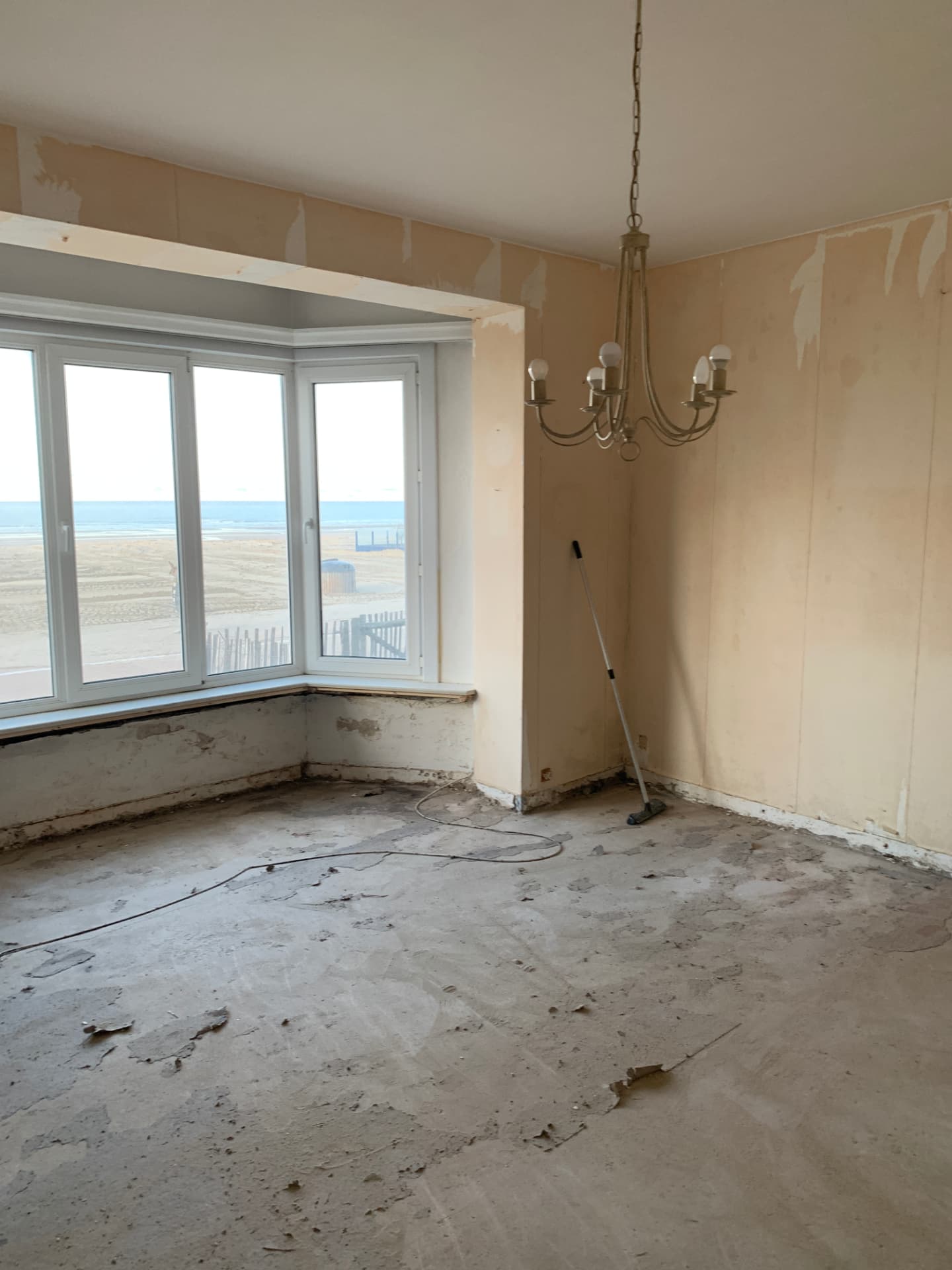 Gestripte leefruimte met erker voor de renovatie